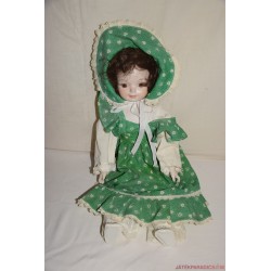 Zöld csipkés ruhás porcelán baba